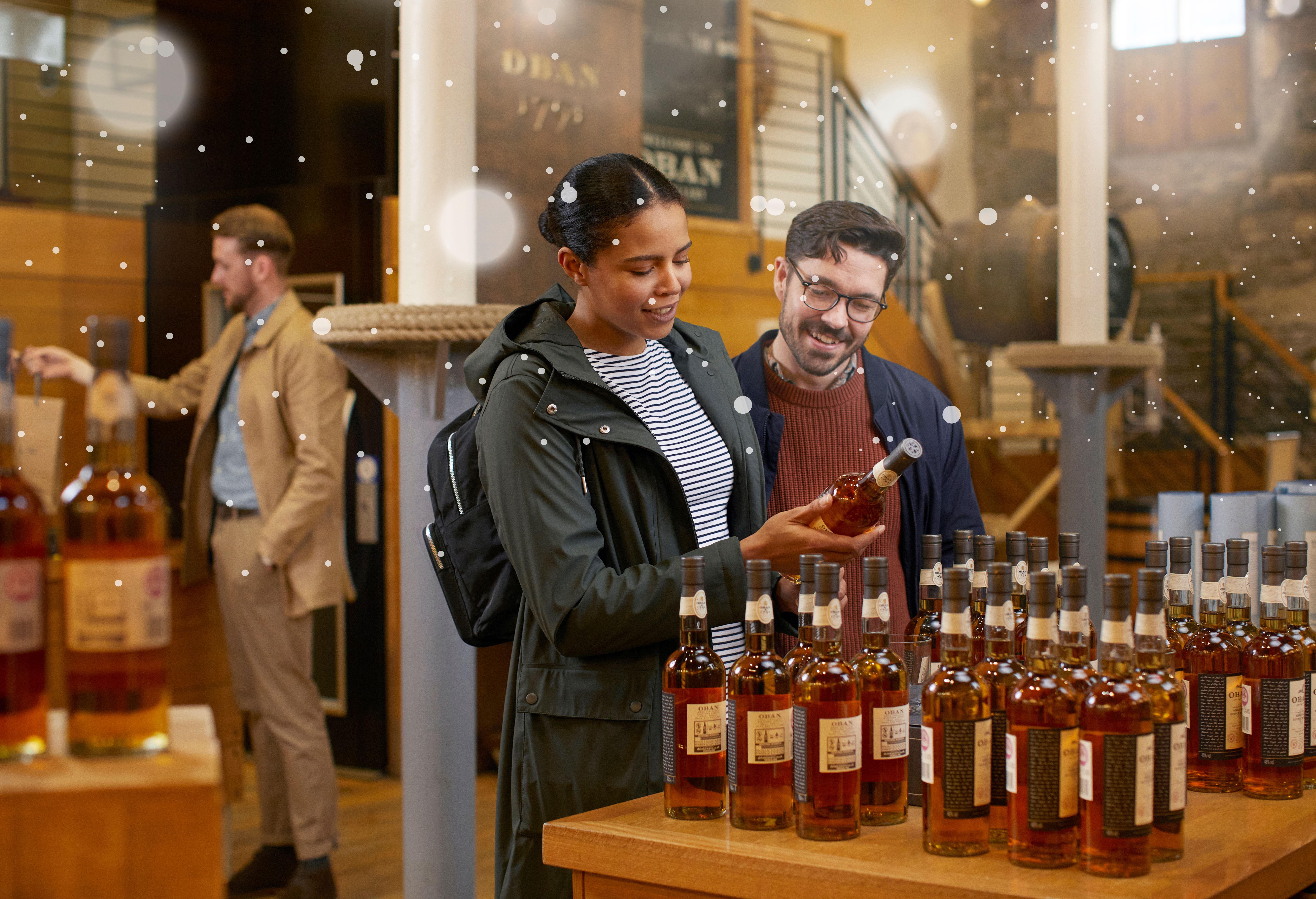 A couple visiting Oban retail shop and checking in one of the Oban special edition bottles 