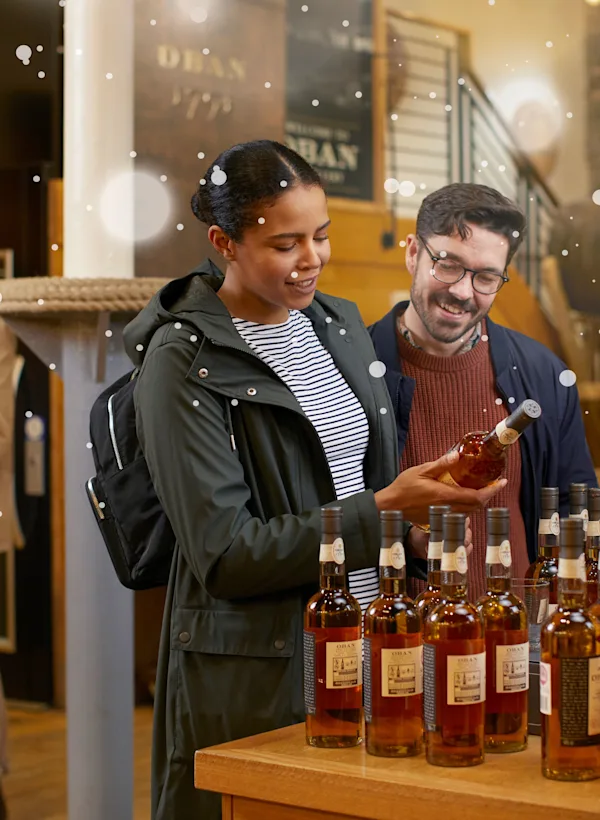 A couple visiting Oban retail shop and checking in one of the Oban special edition bottles