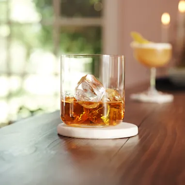 A close up view of a whisky glass with ice
