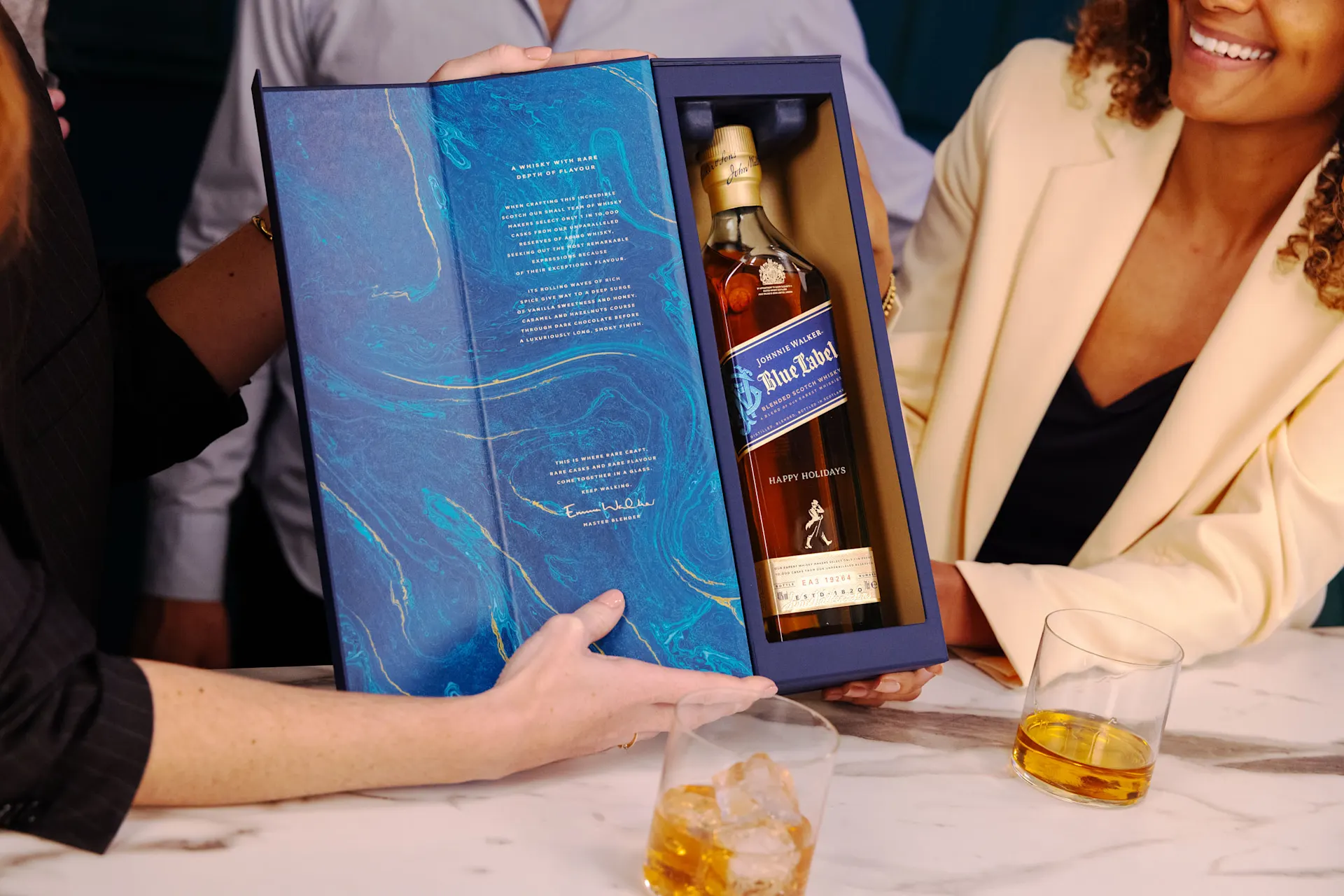 Een fles Talisker 10-Year-Old Single Malt Scotch Whisky op een blauwe en beige achtergrond. Een gouden "Thank You" boodschap is gegraveerd op de fles vlakbij de bodem.