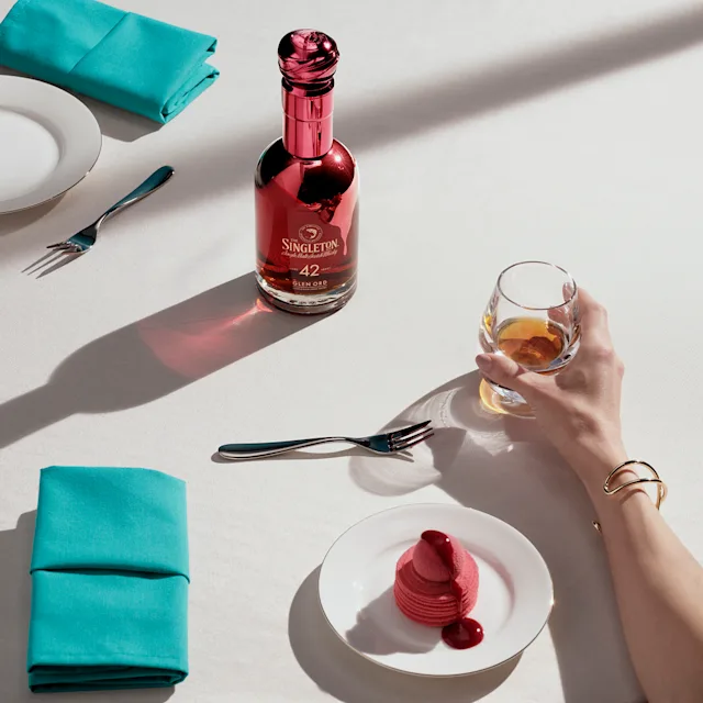 De Singleton fles met een dessert en een glas whisky, met de nadruk op tonen van zwarte kersen gâteau.