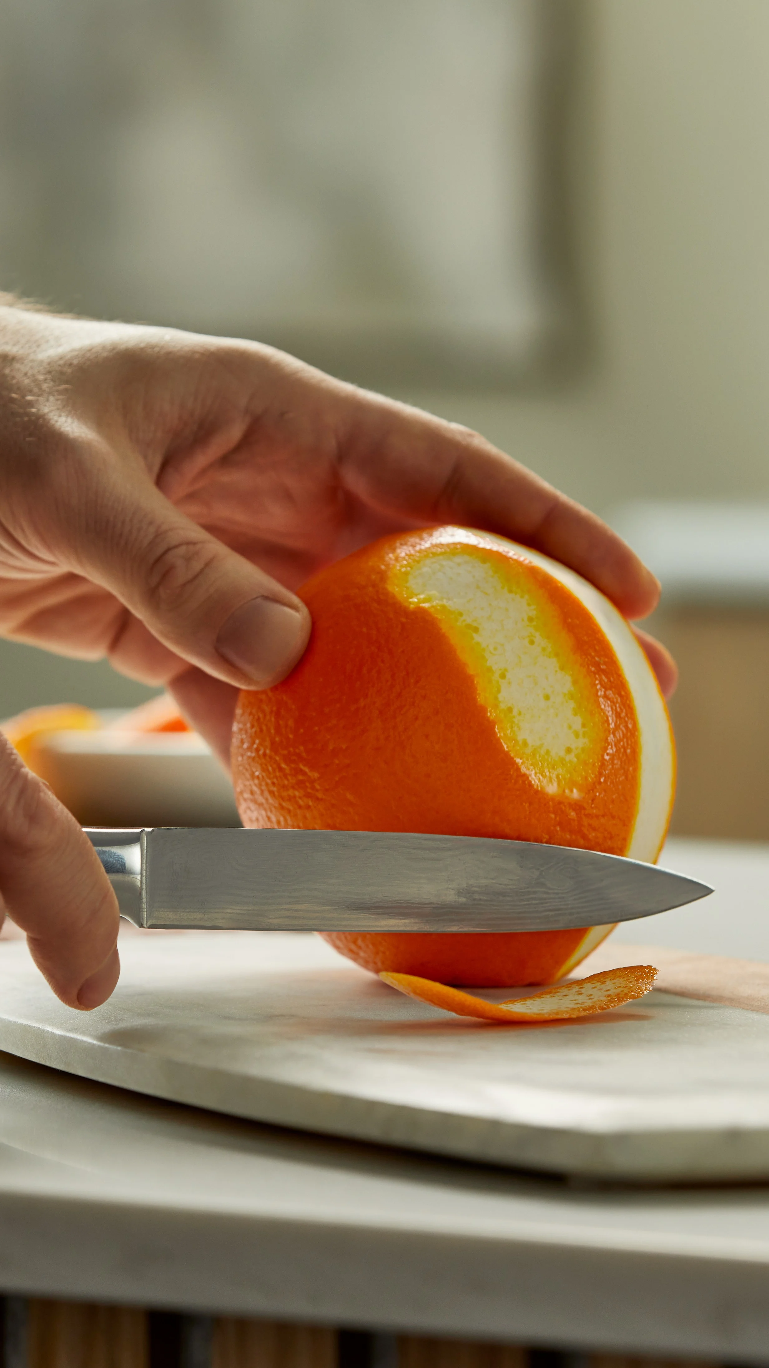 Eine Person schneidet eine Orangenschale