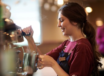 Costa Barista Frau an Maschine Seitenansicht