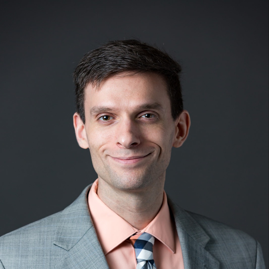 Nathaniel J. Liberty in a gray suit and tie, wearing a peach-colored shirt.