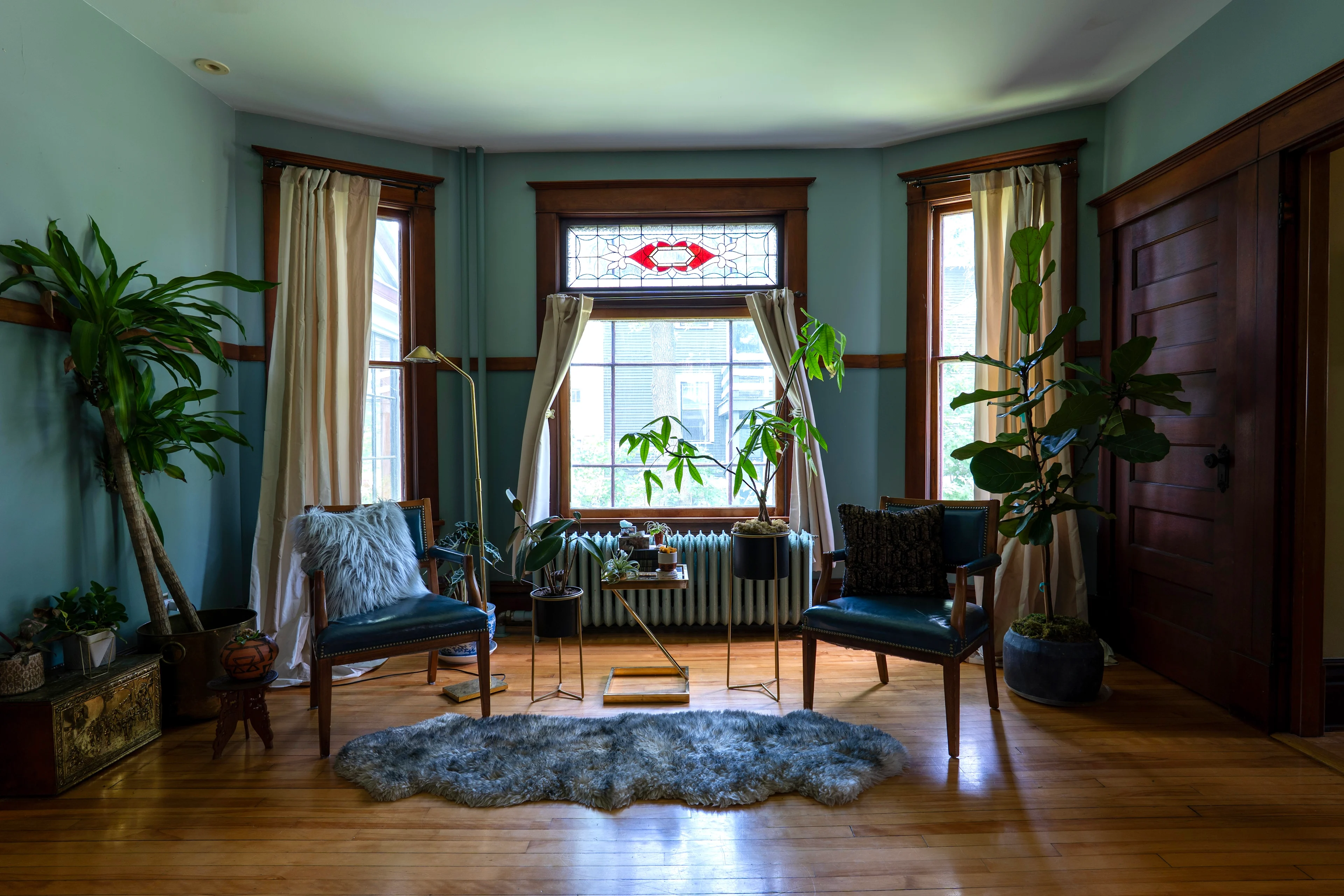 Teal room with original wood trim, picture rail and leather chairs