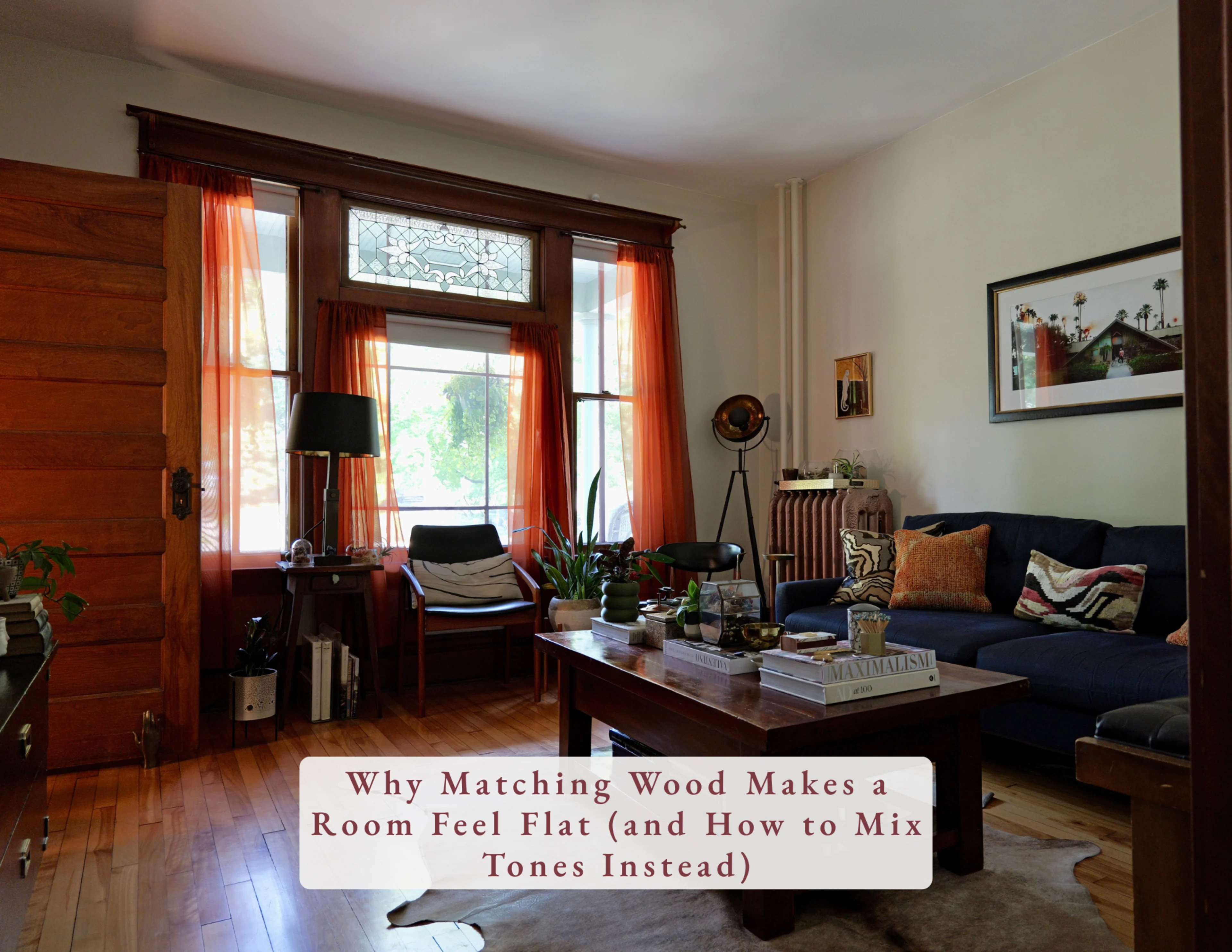 Living room with mixed wood tones, vintage teak and walnut chairs, dark coffee table and honey wood floors