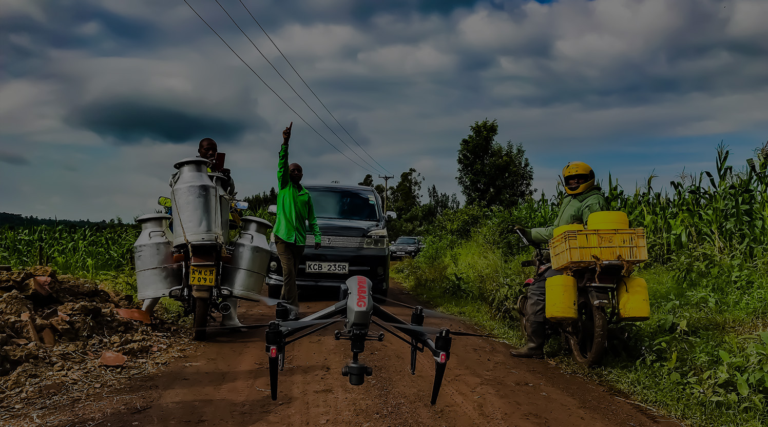 A group watching a drone take off to map a dam in Kenya