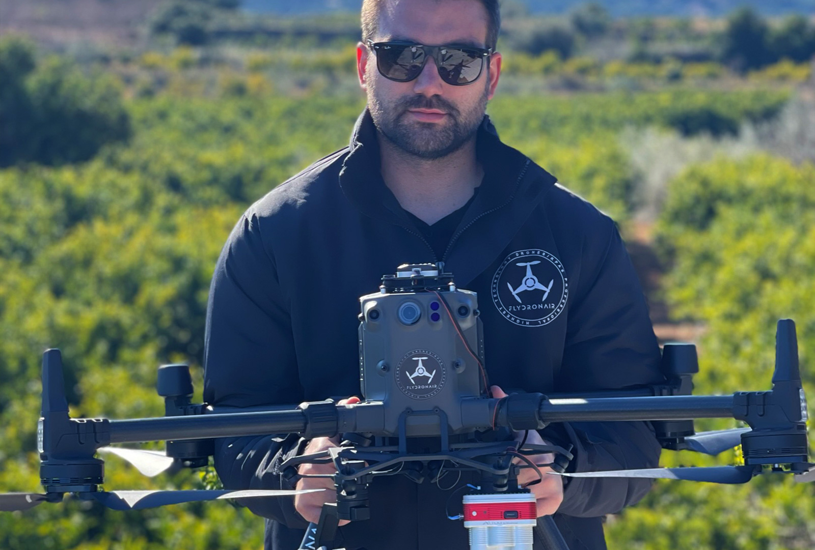 Man in sunglasses holding a DJI M300 drone