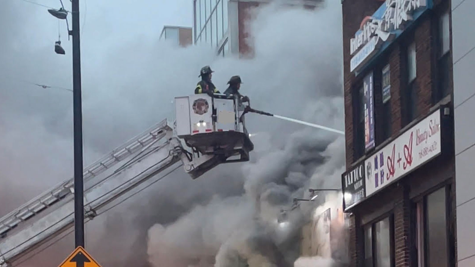 Firefighters spraying water from a ladder