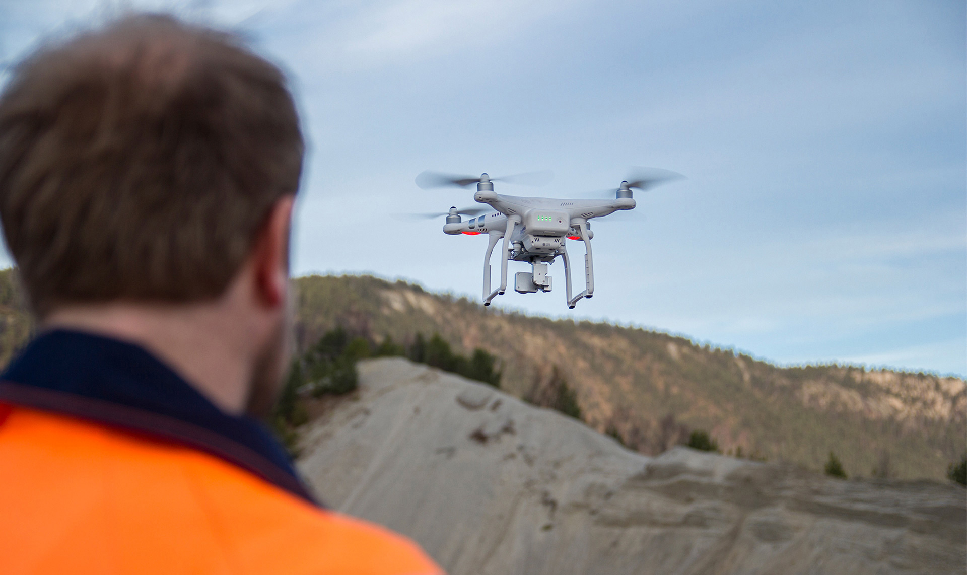 An Isachsen team member flying a drone over a construction site.
