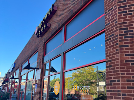 CorePower sign displayed on the exterior of Bucktown's red brick wall and tall glass windows