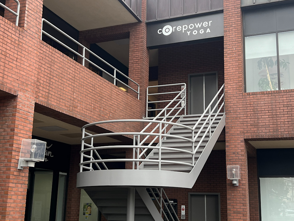 The CorePower Yoga sign on the brick building's upper floor, with the external staircase leading up to the studio