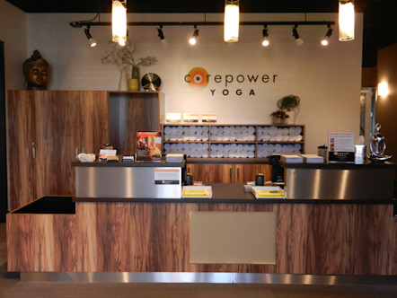 CorePower Yoga sign displayed on a cream linen wallpaper behind wooden cabinetry