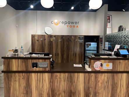 Wooden reception desk displaying a clock and CorePower Yoga sign
