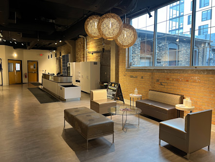 Downtown Minneapolis lobby area with a small seating area with taupe colored couches and a glass coffee table with bohemian orb light pendants above