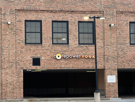 Deep red brick walls with black framed windows touting a CorePower Yoga sign
