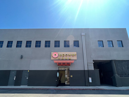 CorePower Yoga sign above a single windowed door on a two-toned grey concrete building 
