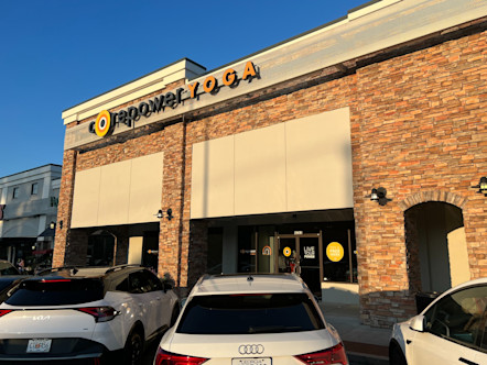 CorePower Yoga sign on the side of a tan stucco building with darker brown and tan stones 