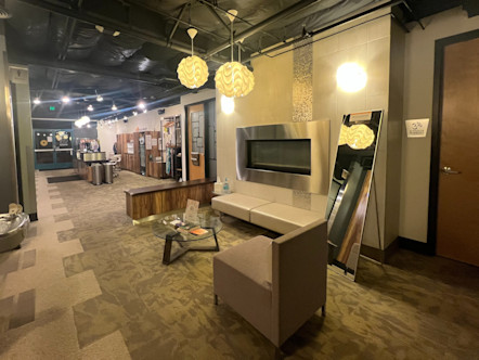 Lobby area with a large metal fireplace centered between two wooden doors and a cream-colored bench underneath