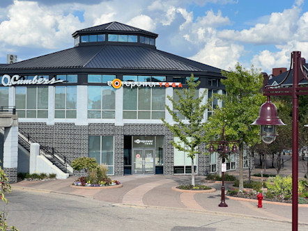 Circular grey brick and white building with windows all surrounding and a white CorePower Yoga sign above one side of the building