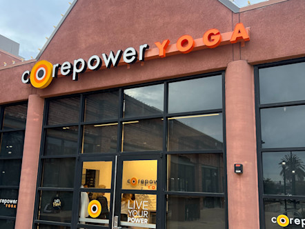 CorePower Yoga sign above a dark mirrored entryway on a red stucco building