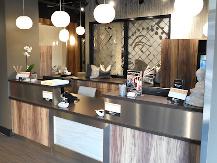 Wooden and brassy silver metallic front desk with ornate paneling behind it