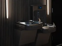 Neon “Live your purpose” sign above two black wall-mounted drinking fountains with vertical lights on dark slats.