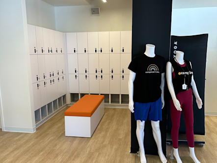 White lockers wrapped around a bright orange bench with mannequins touting CPY merchandise