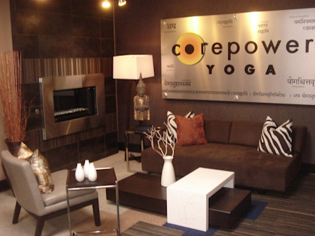Metal CPY sign on brown walls above a brown fabric couch with brown and white zebra print accent pillows 