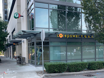 Gray industrial glass building touting a CorePower Yoga sign on the exterior of the building