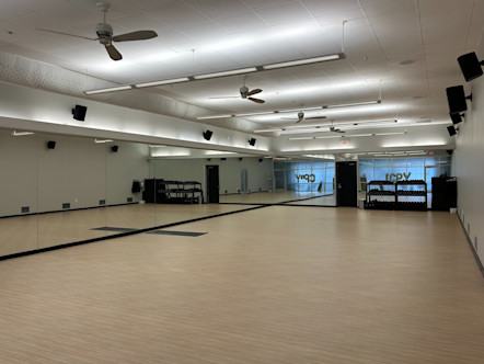 Yoga studio with tan wooden floors and mirrored walls