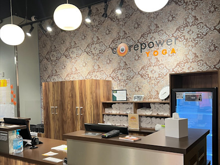 Blackhawk CorePower studio with a wooden front desk and a unique damask wallpaper in neutral colors