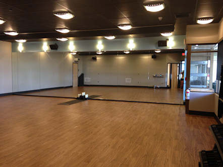 Wooden floor, lights, and mirror inside studio space at Corepower Yoga Kailua