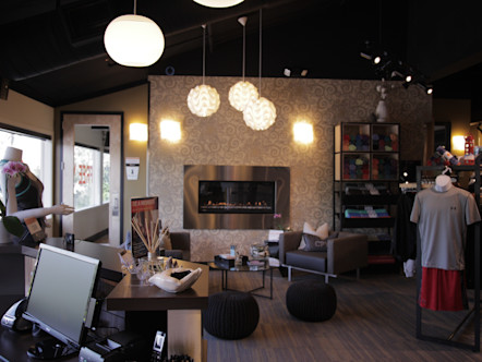 Front desk area with a metal fireplace on a white textured wall behind dark couch seating area