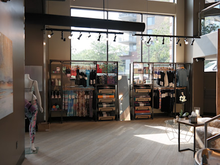 Natural lighting flowing in the large windows into the studio's retail space and lobby area with geometric poufs