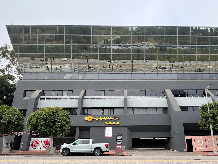 The grey glass office building on Cahuenga Boulevard West with the CorePower Yoga sign above its entrance
