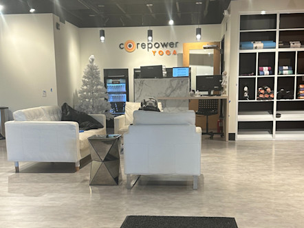 CorePower Yoga sign above a white marble entry table and white couches with colorful yoga gear stocked on the walls