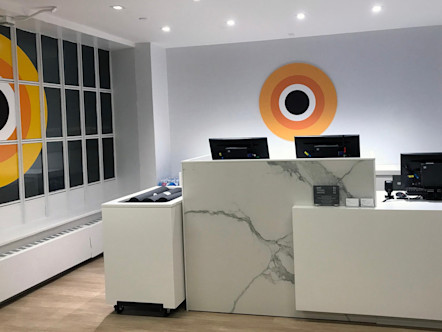 Bryant Park white marbled front desk area with CPY logo behind desks on a white wall