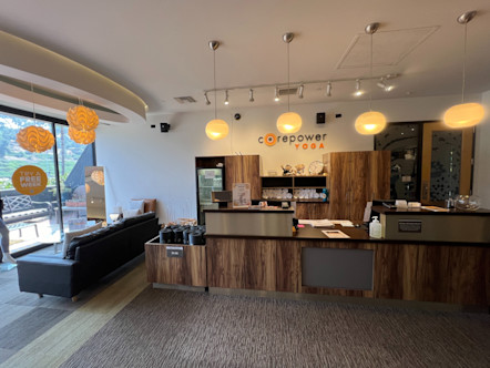 Wooden front desk area with a CPY sign centered behind on a white textured wall 