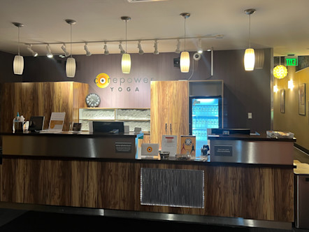 Ballard studio with large wooden paneled front desk in front of purple walls with CPY sign above