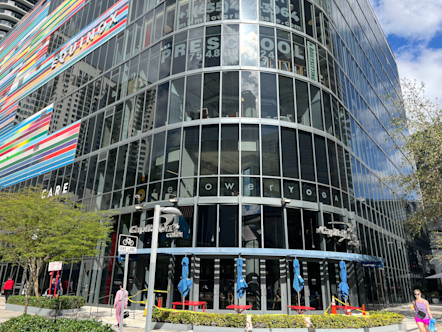 CorePower Yoga Studio on a second floor of a curved corner and fully windowed building above a Capital One Cafe