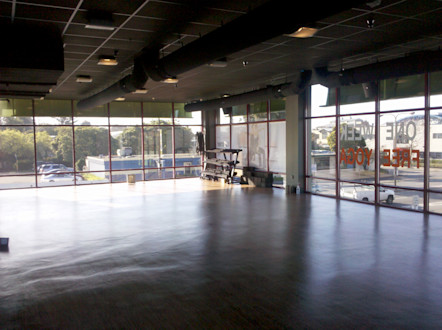 CorePower Yoga Berkley West studio's studio space with floor-to-ceiling glass windows and a weight rack