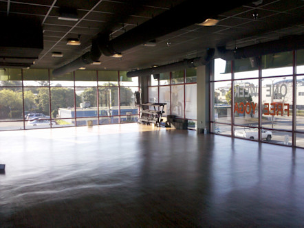 CorePower Yoga Berkley West studio's studio space with floor-to-ceiling glass windows and a weight rack
