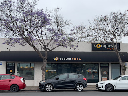 Pacific Beach CorePower Yoga studio with a black awning showcasing the CPY logo on it and a CorePower Yoga sign above it on the right side of the building