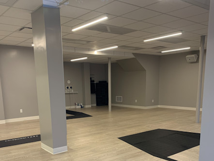 CorePower Yoga NoPa studio's studio space with light wooden floors, mirrored walls, and a gray support column