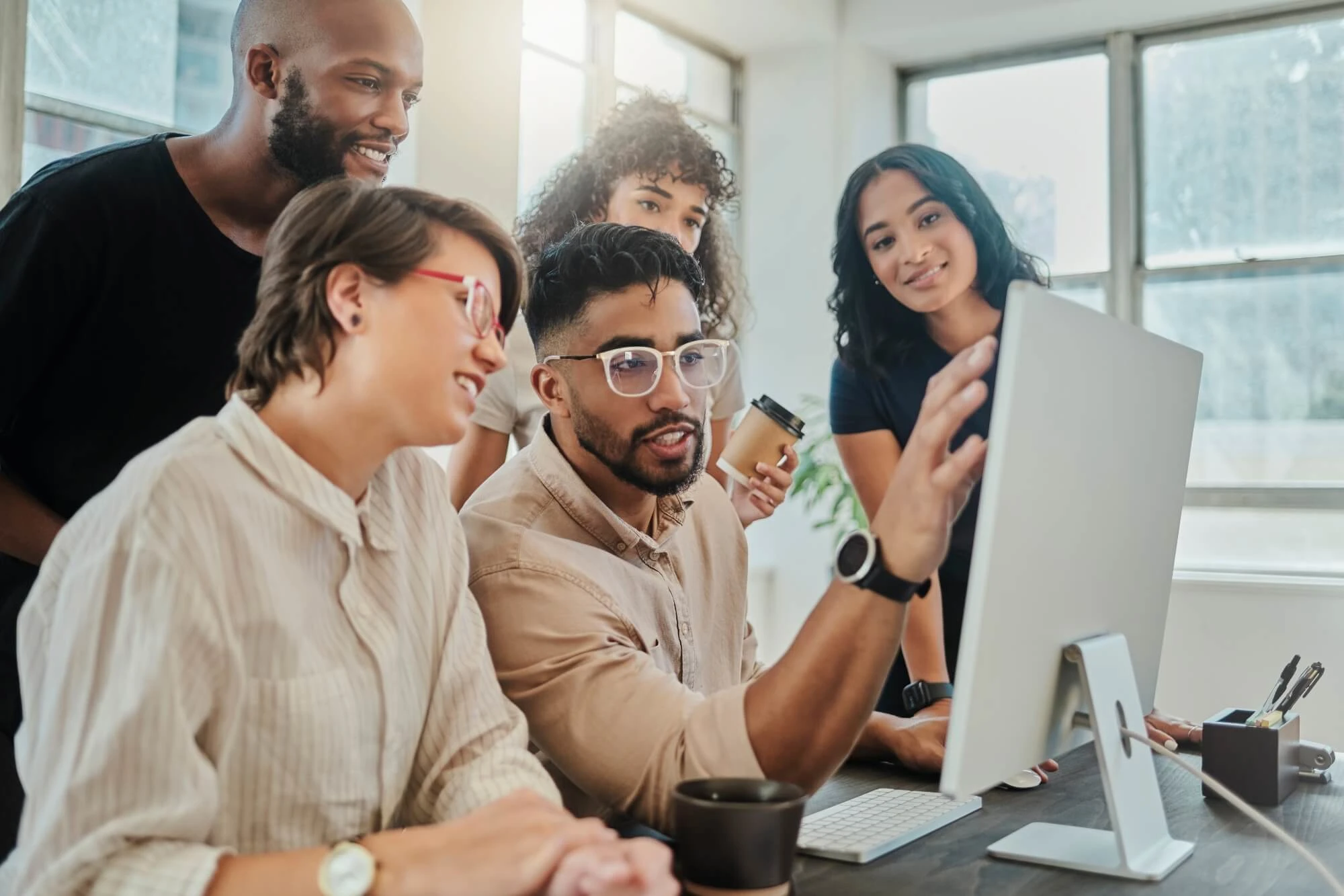 group of people surrounding computer screen