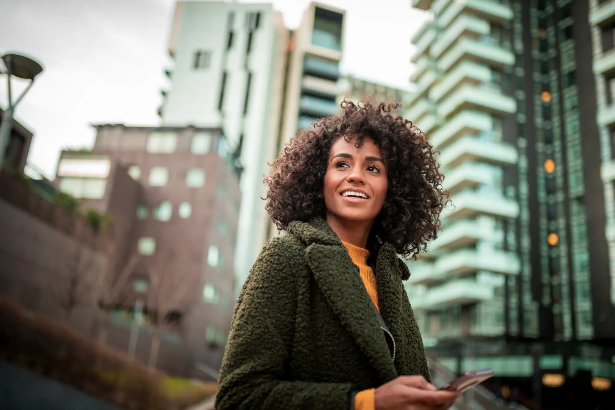 woman with winter coat walking outside in the city