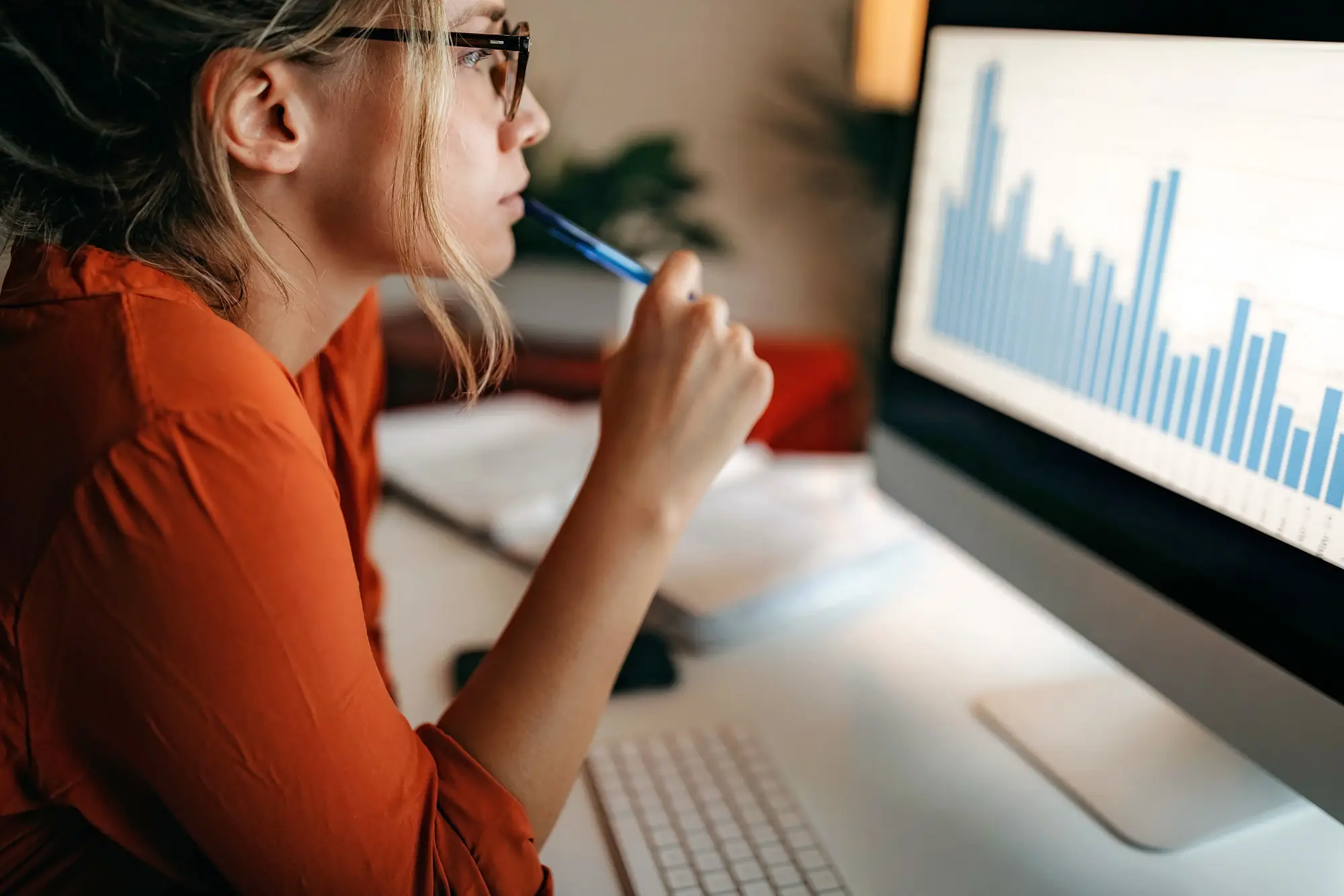 Woman sitting in front of a computer looking at a graph