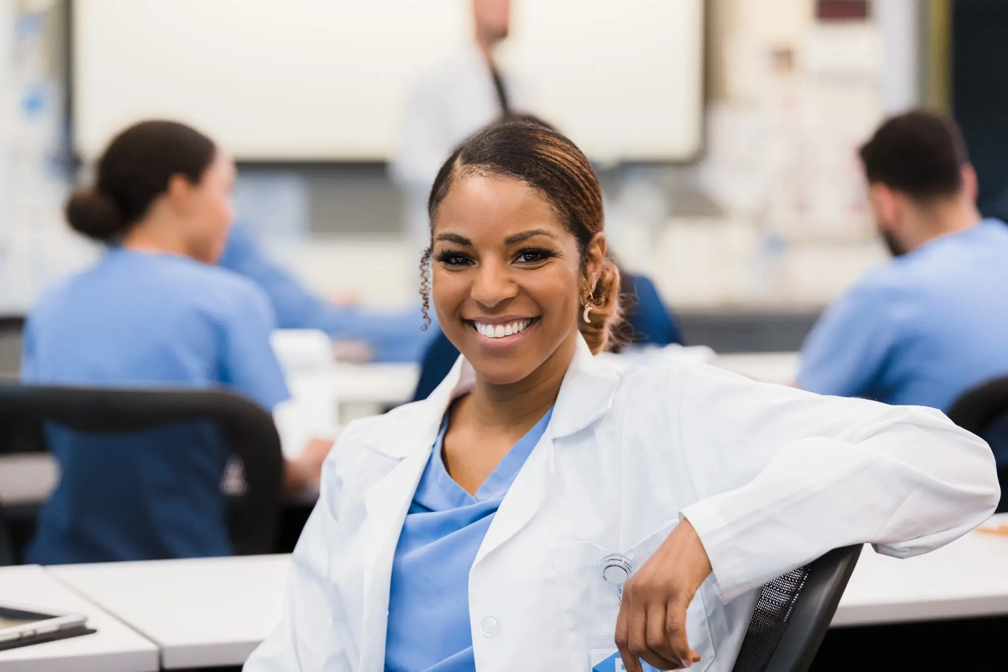 smiling medical woman sitting in classroom