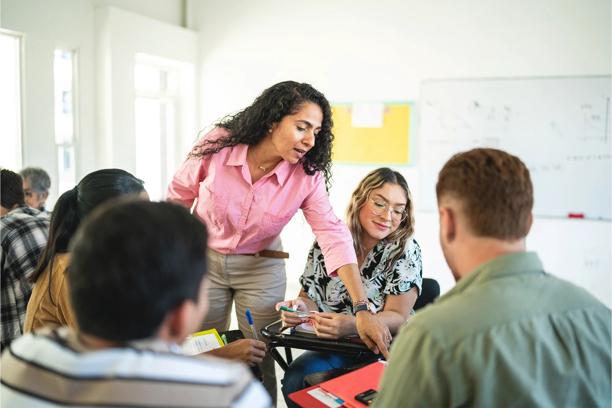 Real estate education instructor addressing students' questions in a classroom.